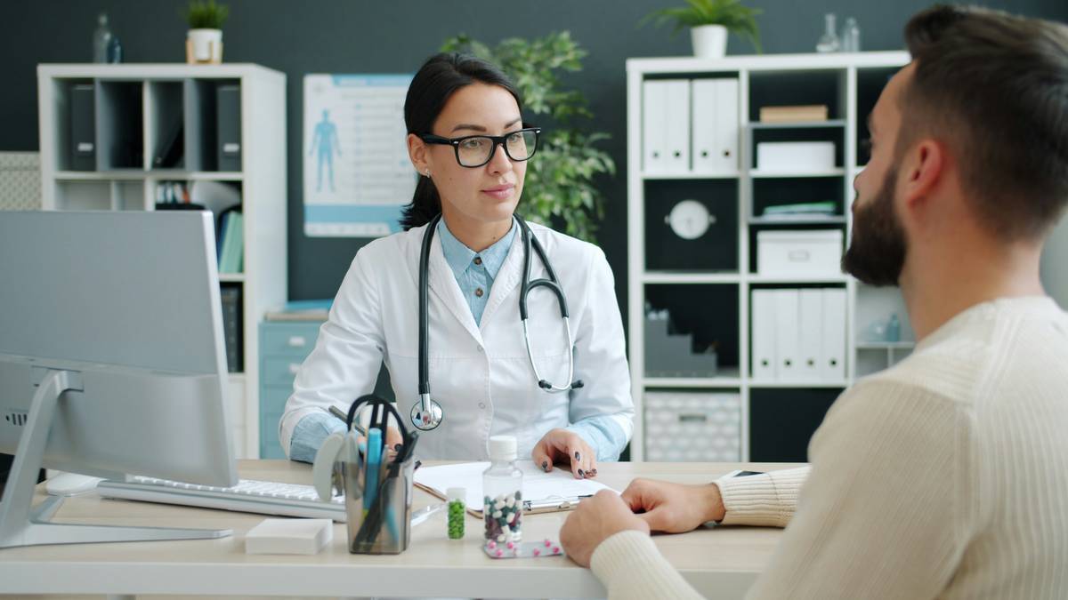 Man reviewing asbestos medical insurance plan documents at kitchen table